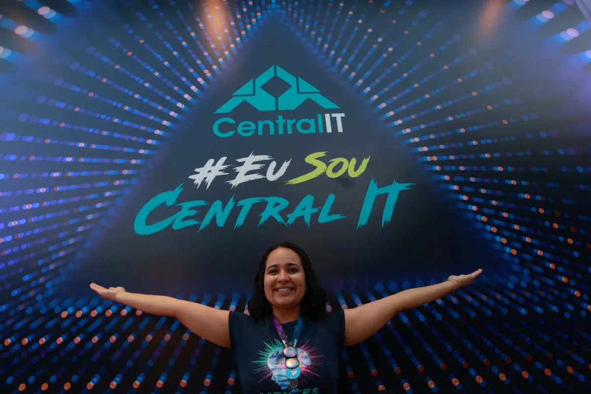 #EuSouCentralITの看板の下で両腕を広げるCentral ITの社員
